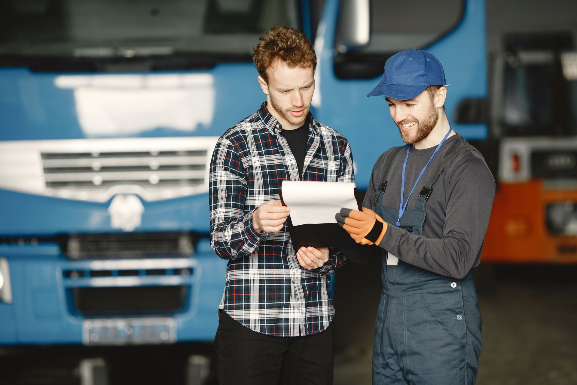 People reviewing vehicle documents beside a commercial vehicle